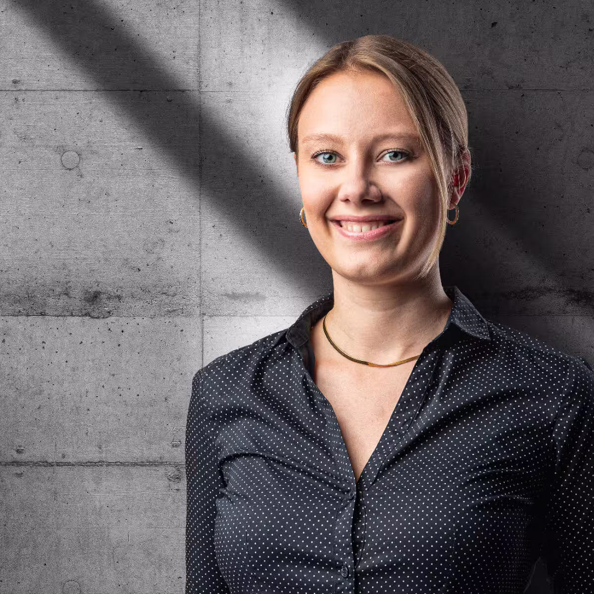 Porträt einer Mitarbeiterin von engineering people vor Betonwand