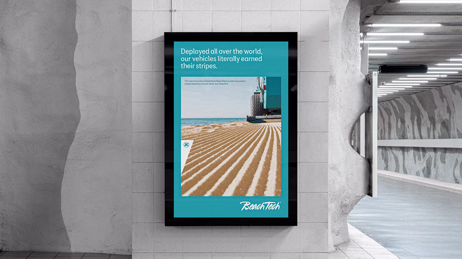BeachTech-Plakat in U-Bahn-Station mit Nahaufnahme gereinigter Sandfläche und Fahrzeug am Strand.
